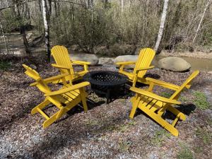 two yellow chairs sitting next to a fire pit at Caney Creek in Jenkins Mill