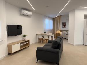a living room with a couch and a tv at Apartamentos San Antonio - GrupoAMI in Ontinyent