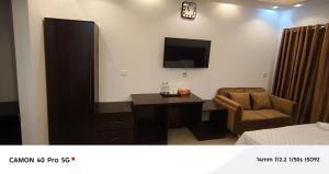 a room with a desk and a tv and a chair at Park Amaira Banani Guesthouse in Dhaka