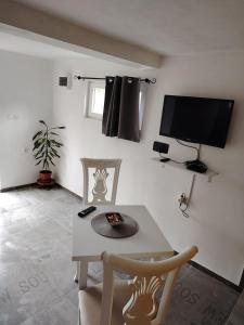 a living room with a table and a tv at Rural Resort Tron - Rooms in Plužine