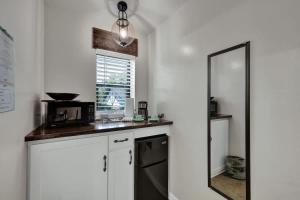 a kitchen with a microwave and a mirror at Tejas Suite Walking Distance to Main St! in Fredericksburg +6 photos
