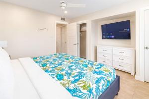 a white bedroom with a bed and a flat screen tv at La Internacional 313 in South Padre Island +58 photos