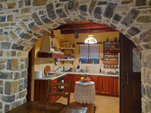 a kitchen with an archway in a stone wall at Evenos Stone Villa in Ierapetra