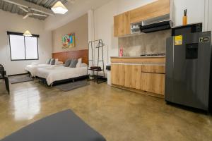 a living room with two beds and a refrigerator at Malibu loft hotel in Medellín
