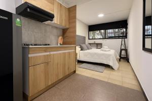 a kitchen and a bedroom with a bed in a room at Malibu loft hotel in Medellín +20 photos