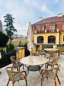 a group of tables and chairs in front of a building at Pałac w Rymaniu in Rymań