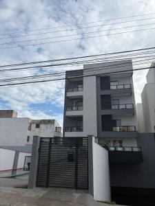 a building with a gate in front of it at Smart Studio Lavras in Lavras