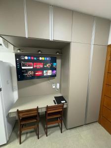a room with a table and two chairs and a tv at Smart Studio Lavras in Lavras