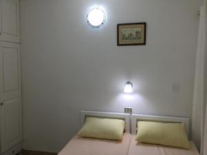 a bed with two pillows and a light on the wall at Mini-Studio With Free Private Beach in Hurghada