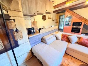 a living room with a couch and a kitchen at La Grange de Bosc -Ardèche verte - Proche train de Lamastre in Saint-Prix