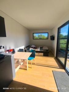 a room with a table and a bed and a bedroom at Tiny House, 12mn du Parc, Terrasse & Clim in Châteaumur