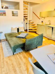a living room with a green couch and a kitchen at b3 - bike & bed bitterfeld in Bitterfeld