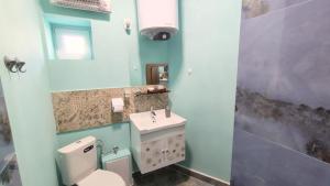 ein Badezimmer mit weißer Toilette und Waschbecken in der Unterkunft Уютно Централно Студио Враца in Vratsa