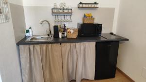 a kitchen counter with a sink and a microwave at La Dimora di Alma in Clivio +17 photos