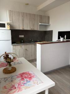 a kitchen with a table with a vase of flowers on it at Hirondelles 3 in Eugénie-les-Bains