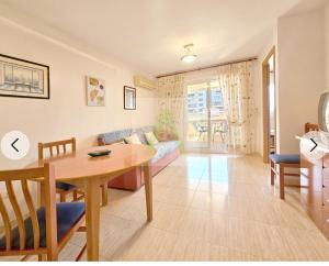 a living room with a table and a couch at Beachfront apartment in Oropesa del Mar