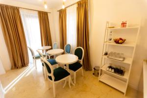 a dining room with two tables and chairs and a window at Jolie Boutique Hotel in Craiova