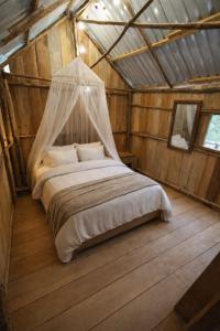 a bedroom with a bed with a mosquito net at Cabañas Kapuy in Florencia