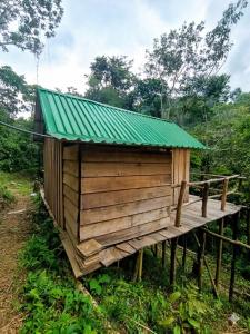 a small wooden building with a green roof at Cabañas Kapuy in Florencia