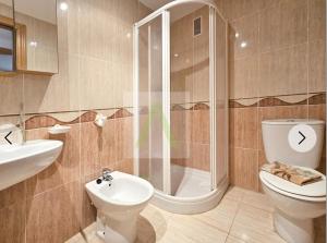 a bathroom with a shower and a toilet and a sink at Beachfront apartment in Oropesa del Mar +8 photos