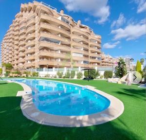 a large apartment building with a large swimming pool at Beachfront apartment in Oropesa del Mar