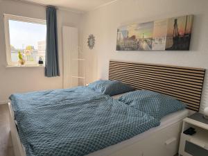 a bedroom with a bed with blue sheets and a window at Ferienwohnung-Maren in Marienleuchte