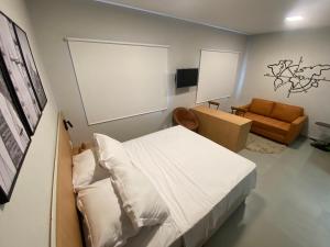 a bedroom with a bed and a couch in it at Flat em Alphaville - Super Novo in Barueri