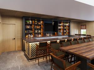 a bar in a restaurant with wooden tables and chairs at Hotel Bridgton in Bridgton