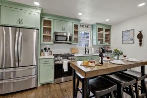 a kitchen with green cabinets and a large refrigerator at Southern Charm - Near Main With Hot Tub in Fredericksburg