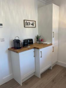 a kitchen with white cabinets and a wooden counter top at Watermark Luxury Accommodation in Portmagee