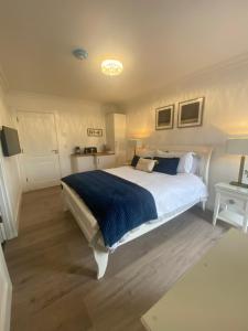 a bedroom with a large bed with a blue blanket at Watermark Luxury Accommodation in Portmagee