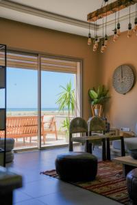 a living room with a table and chairs and a large window at YMY Beach House in Agadir