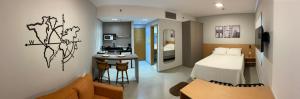 a small bedroom with a bed and a kitchen at Flat em Alphaville - Super Novo in Barueri +11 photos