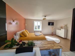 a bedroom with a bed with yellow pillows at La clé des songes in Cellefrouin