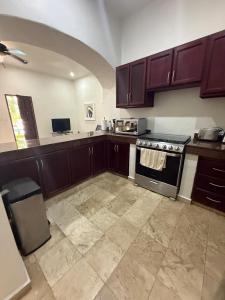 a kitchen with brown cabinets and a stove in it at Spacious 3 bedroom Condo by Mamitas beach in Playa del Carmen
