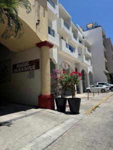 a building with two potted plants in front of it at Spacious 3 bedroom Condo by Mamitas beach in Playa del Carmen