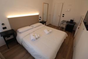 a bedroom with a white bed with towels on it at Hotel Noto Marina Meeting Vista Mare in Noto Marina