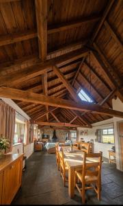 a dining room with a table and wooden ceilings at Haytor Rocks, Dartmoor escape in Bovey Tracey