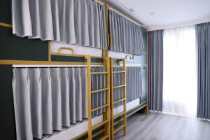 a room with bunk beds with grey curtains at Beshic Hostel in Tashkent