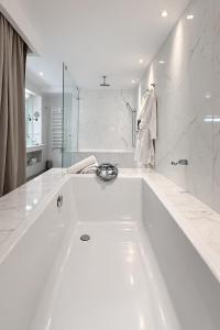 a large white bath tub in a white bathroom at BAB HOTEL Marrakech, Boutique Hôtel & SPA in Marrakesh +28 photos