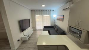 a living room with a couch and a tv at Turquesa 10 in La Pineda +1 photo