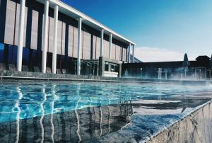 a swimming pool in front of a building at Ferienwohnungen an der RupertusTherme in Bad Reichenhall
