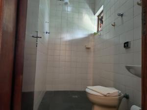 a bathroom with a toilet and a sink at Pousada e Chalés Santorini in Caraguatatuba
