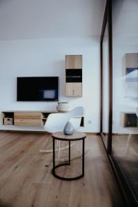 a living room with a tv and a table at Apart Veronika Imst - Exklusiv Wohnen in Imst in Imst