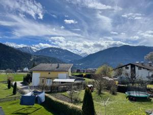 a house in a field with mountains in the background at Apart Veronika Imst - Exklusiv Wohnen in Imst in Imst