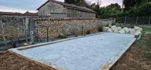 a basketball court in a yard next to a brick wall at La clé des songes in Cellefrouin