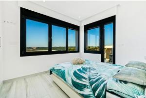 a bedroom with white walls and windows and a bed at Casa Phillips in Orihuela Costa