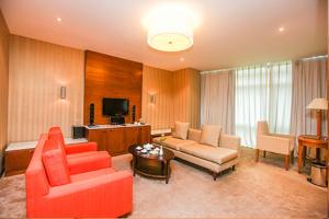 a living room with red furniture and a flat screen tv at Petro Hotel in Vung Tau