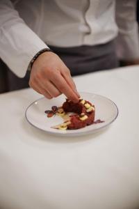 a person reaching for a piece of food on a plate at Le Conche country house in Villamaina