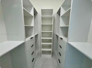 a white walk in closet with white shelves at Beautiful House Near Marlins Stadium in Miami